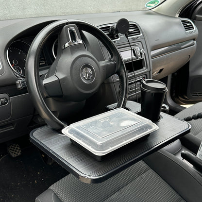 Essensbox und Kaffeebecher auf der Ablage am Lenkrad