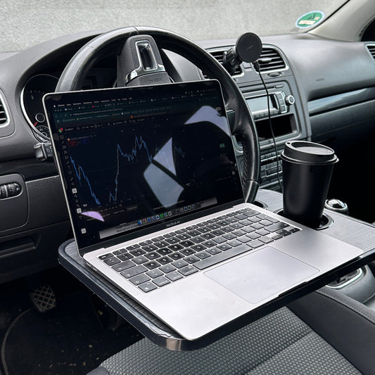 CarBuddy Pro II am Lenkrad mit aufgeklapptem Laptop und Kaffeebecher